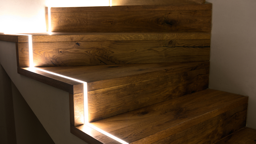 escaleras de madera con una tira de luces led 